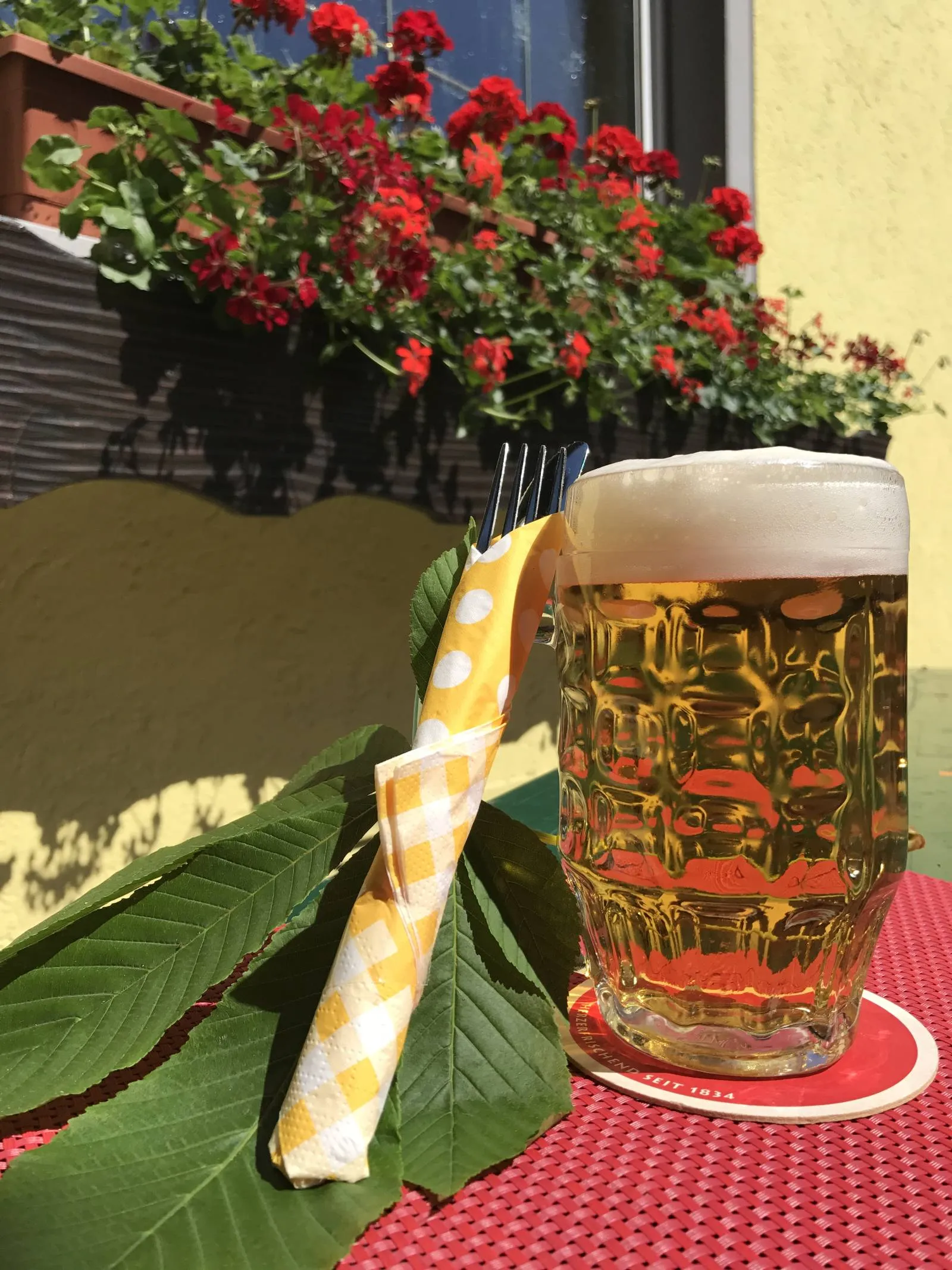 Frisch gezapftes Bier mit Kastanienblättern